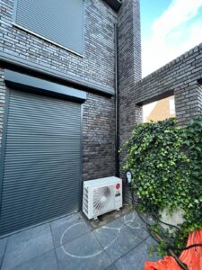 rolluiken of airco bij woning met buitenunit en zonwering tegen hitte