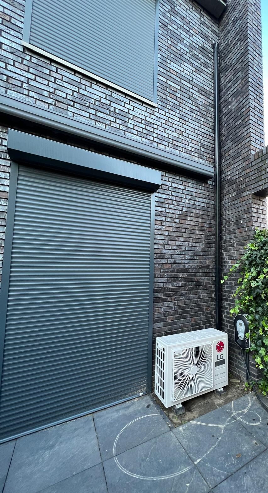 rolluiken of airco bij woning met buitenunit en zonwering tegen hitte